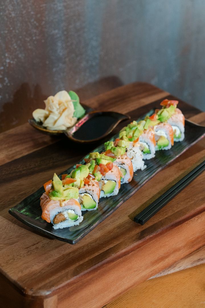 Lachs Avocado Rolls auf Holzbrett mit Ingwer und Sojasauce
